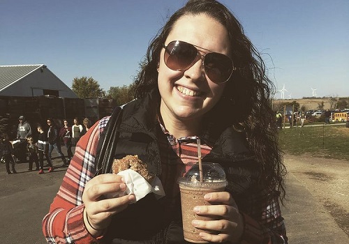 A woman smiles and enjoys the foods available from Tanners Orchard, one of the top Orchards for Freeport IL residents