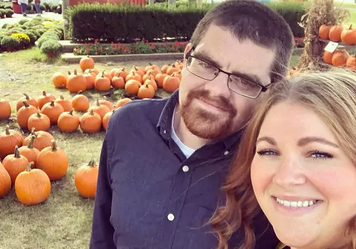 A couple pose with pumpkins at Tanner's Orchard, which offers Fall Activities for Champaign IL residents