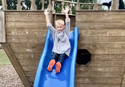 A boy slides down a slide at Tanner's Orchard, which offers numerous Fun Fall Activities for the whole family