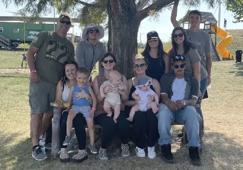 A family poses in front of a tree during their visit to Tanners Orchard